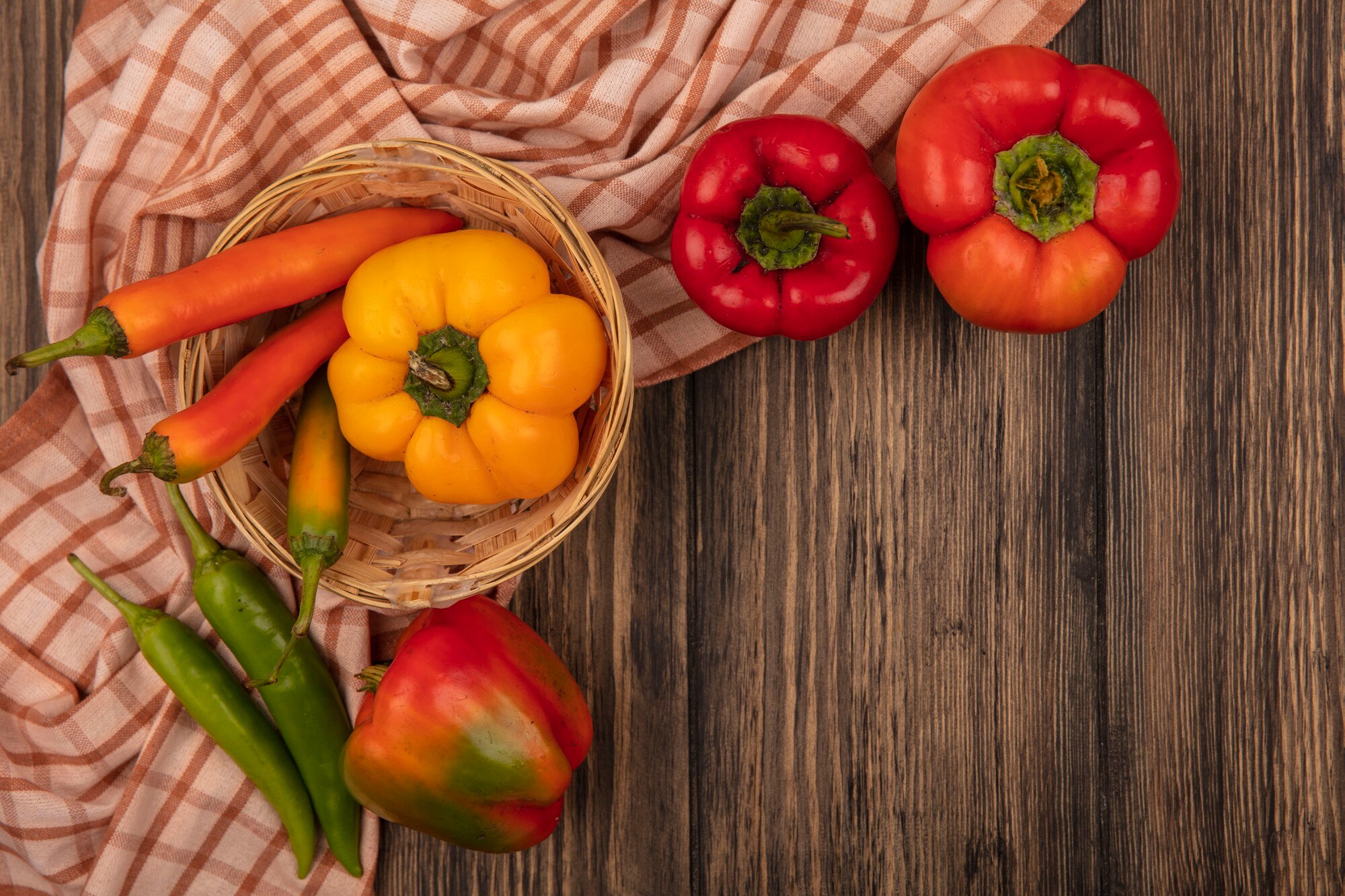 Mesa con frutas y verduras frescas de colores vivos, tomates, pimientos, naranjas y hojas verdes